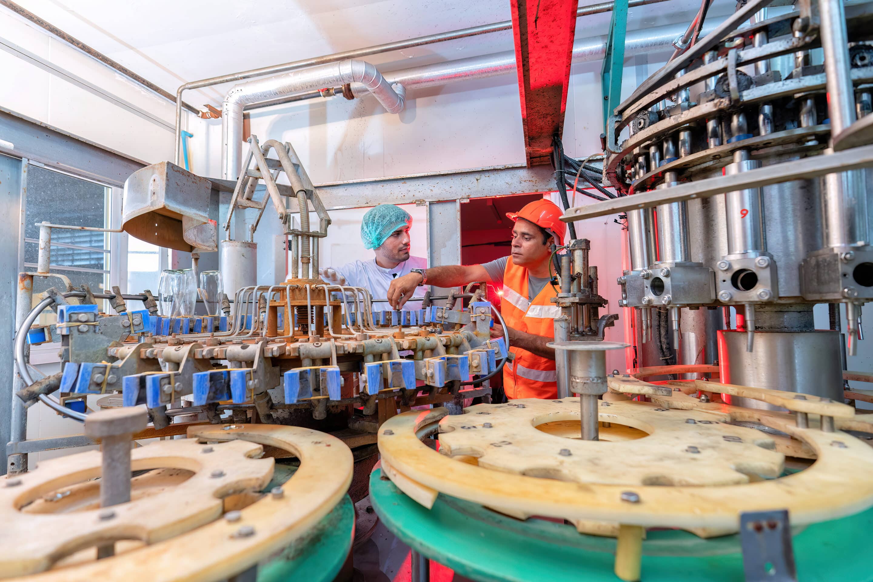 Deux opérateurs en équipement de sécurité contrôlant une machine de production industrielle automatisée