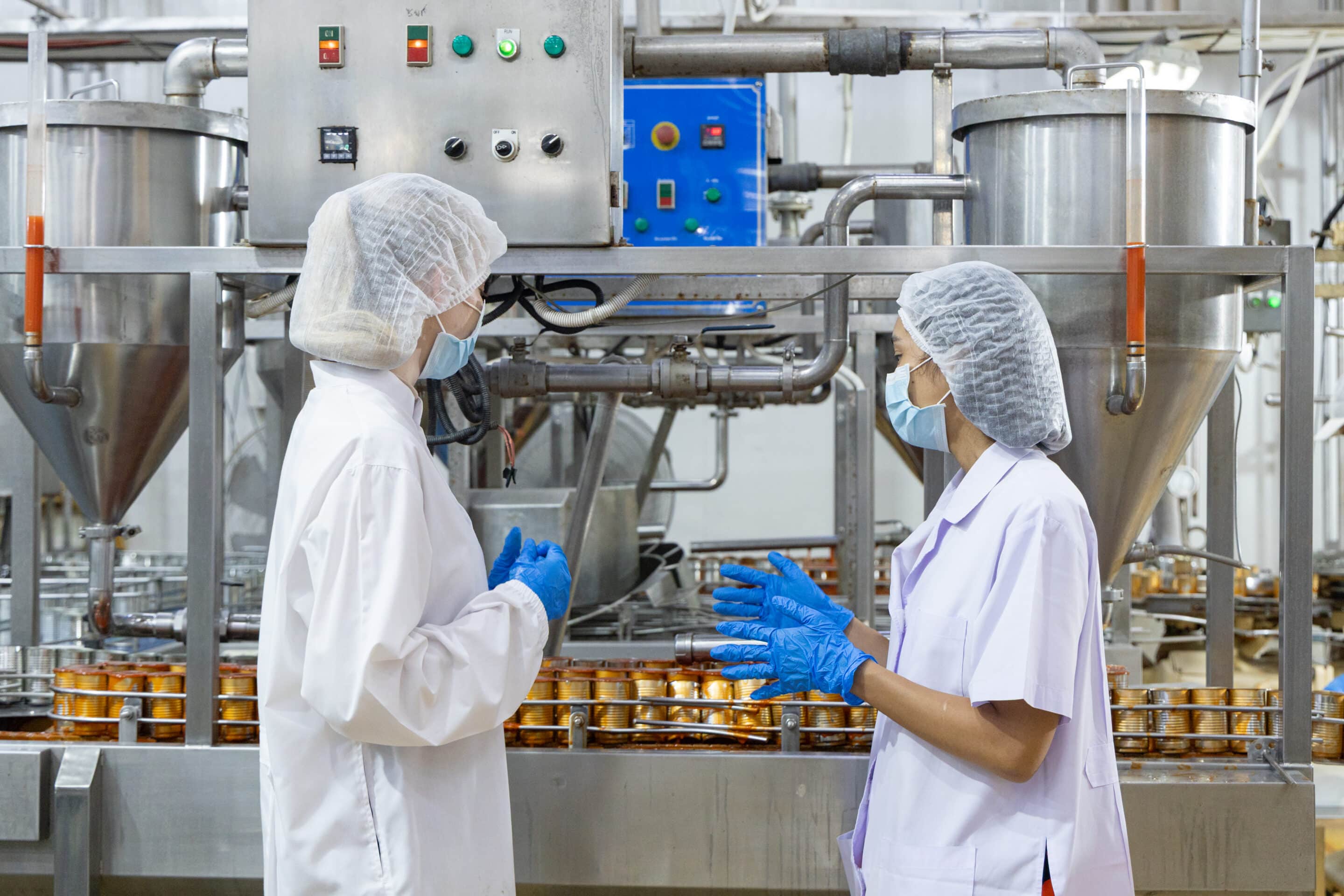 Opérateurs en usine agroalimentaire surveillant une ligne de production automatisée pour optimiser l'OEE et la productivité