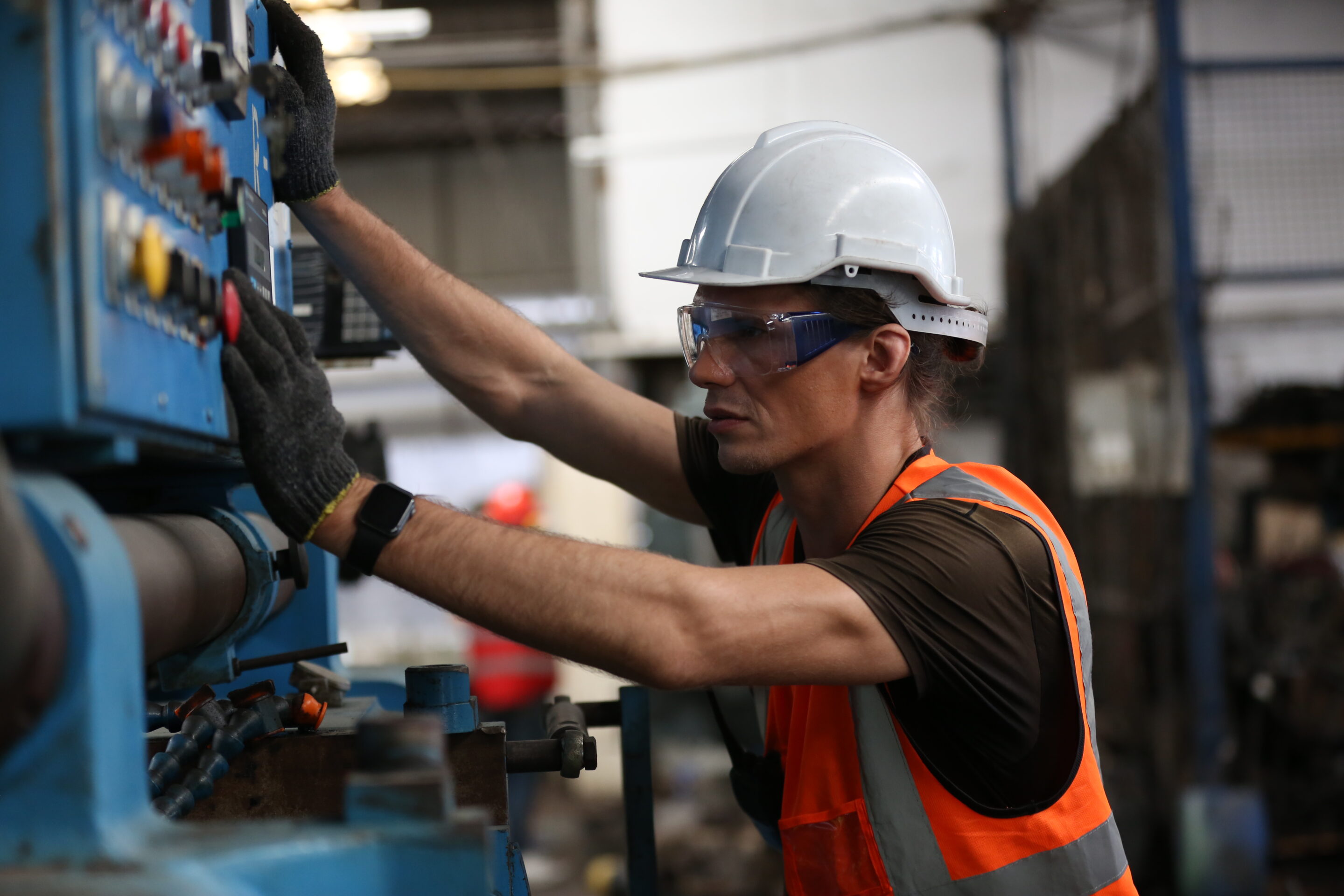 lathe worker working with milling machine in metal industry. Opérateur en usine pilotant la production en temps réel sur panneau de contrôle industriel pour optimiser l'OEE