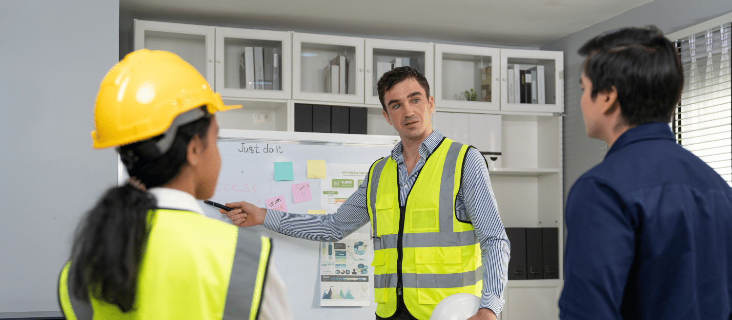 Responsable de production présentant un projet d'amélioration à son équipe devant un tableau de bord